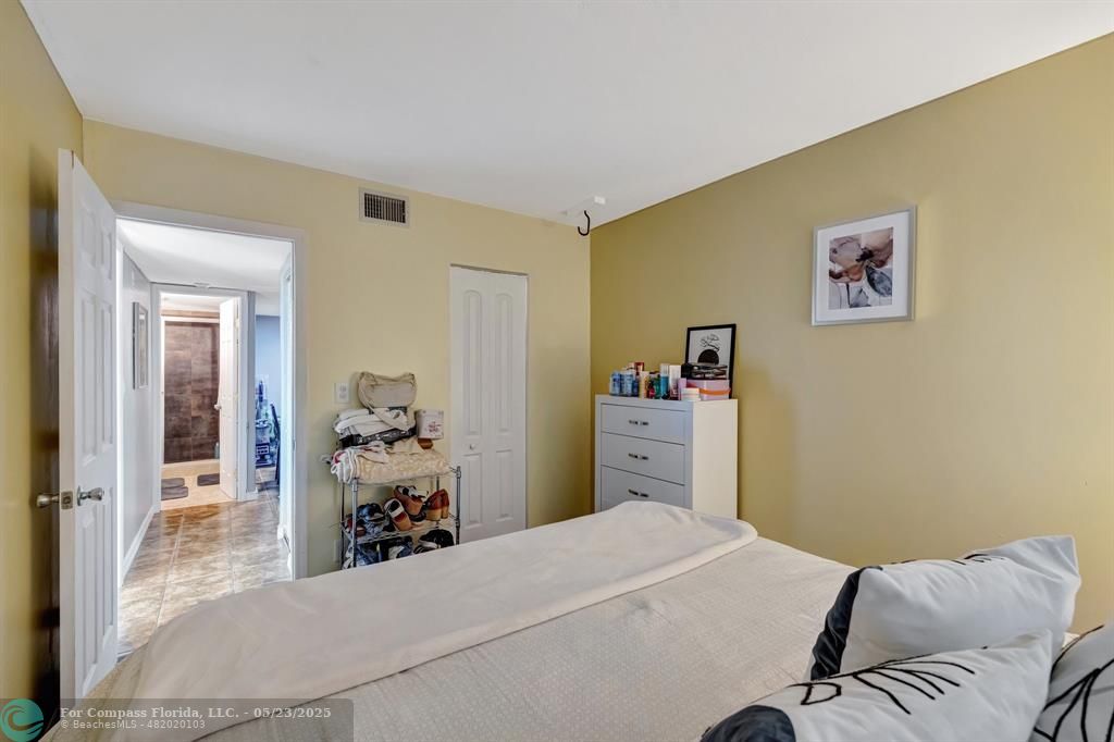 3004 Northeast 5th Terrace, Unit 208C Wilton Manors, FL 33334 - Photo 23 of 63 a bedroom with a bed and a large mirror