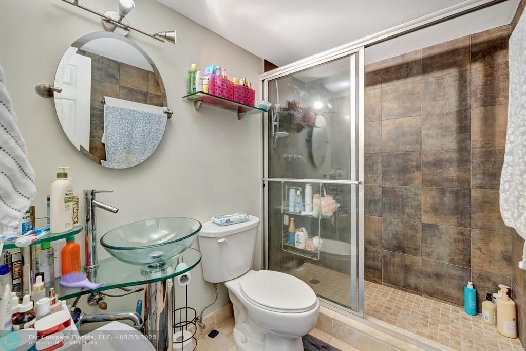 3004 Northeast 5th Terrace, Unit 208C Wilton Manors, FL 33334 - Photo 24 of 63 a bathroom with a toilet a sink and shower