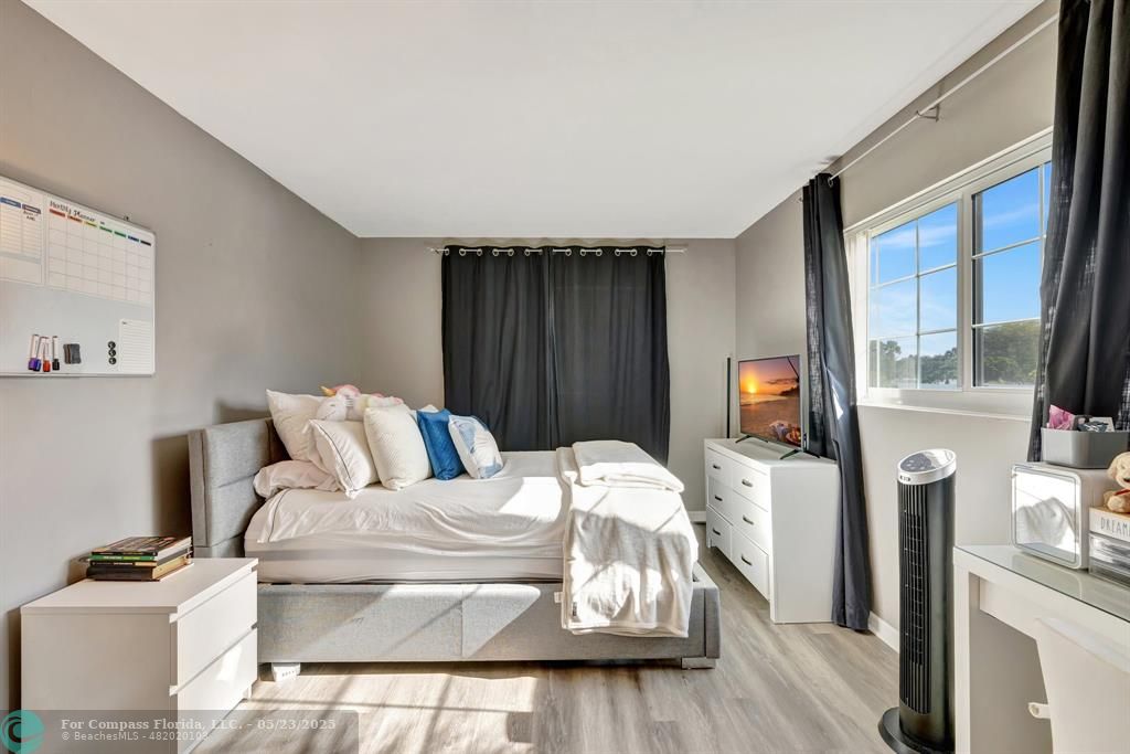 3004 Northeast 5th Terrace, Unit 208C Wilton Manors, FL 33334 - Photo 27 of 63 a living room with furniture a flat screen tv and a fireplace