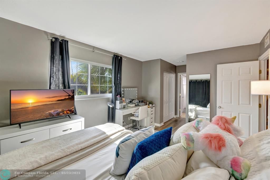 3004 Northeast 5th Terrace, Unit 208C Wilton Manors, FL 33334 - Photo 28 of 63 a bedroom with bed and a flat screen tv