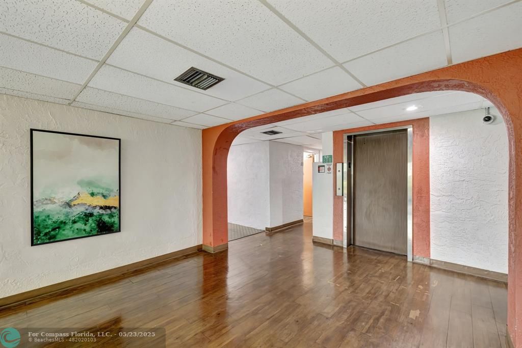 3004 Northeast 5th Terrace, Unit 208C Wilton Manors, FL 33334 - Photo 33 of 63 a view of a hallway with wooden floor and a ceiling fan