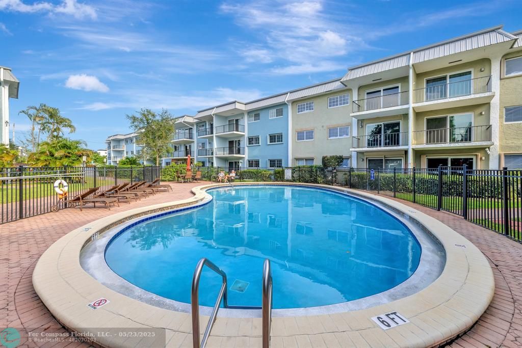 3004 Northeast 5th Terrace, Unit 208C Wilton Manors, FL 33334 - Photo 44 of 63 a swimming pool with outdoor seating and yard