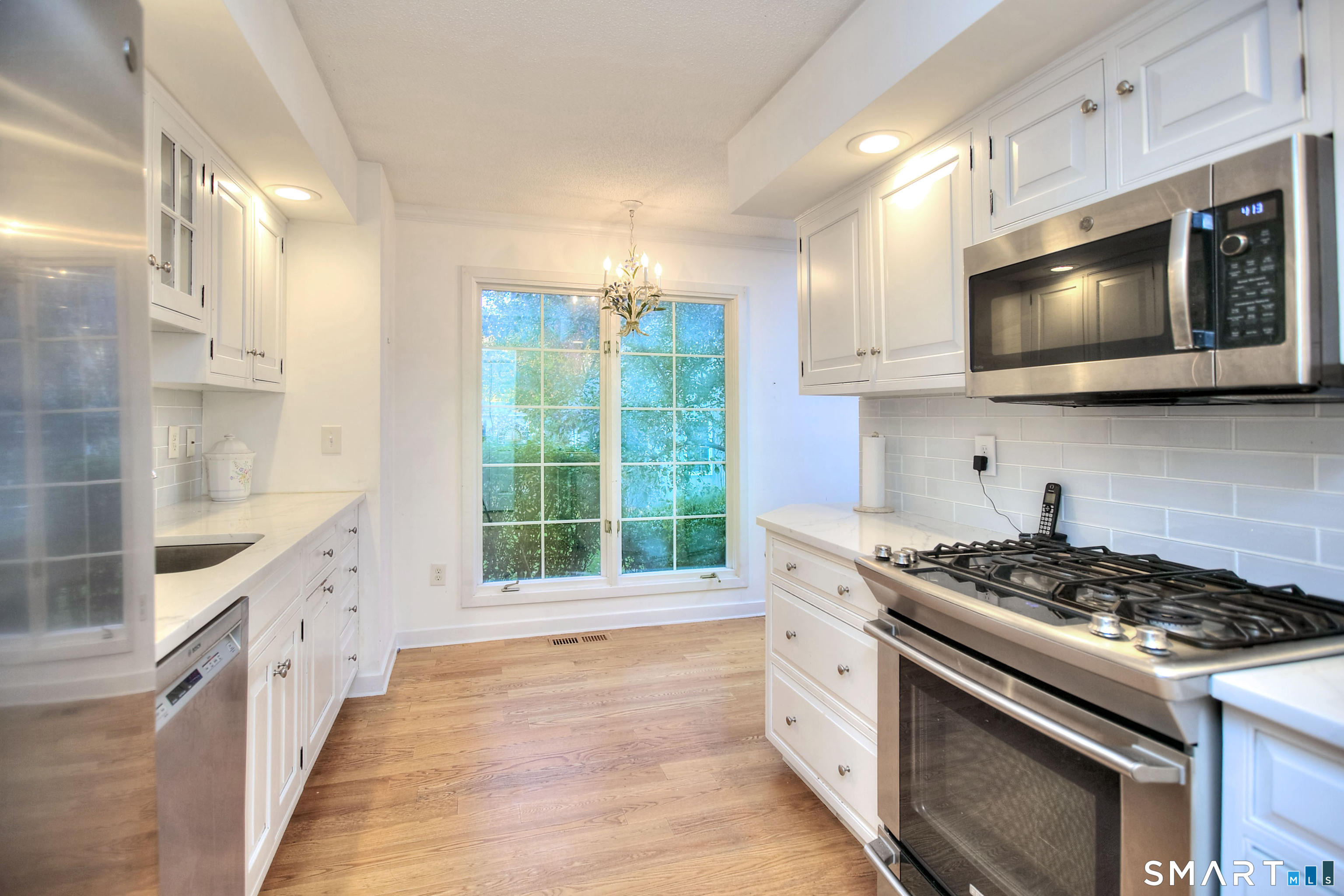 160 Glengarry Road, Unit 160 Fairfield, CT 06825 - Photo 13 of 31 a kitchen with stainless steel appliances a stove a microwave and cabinets