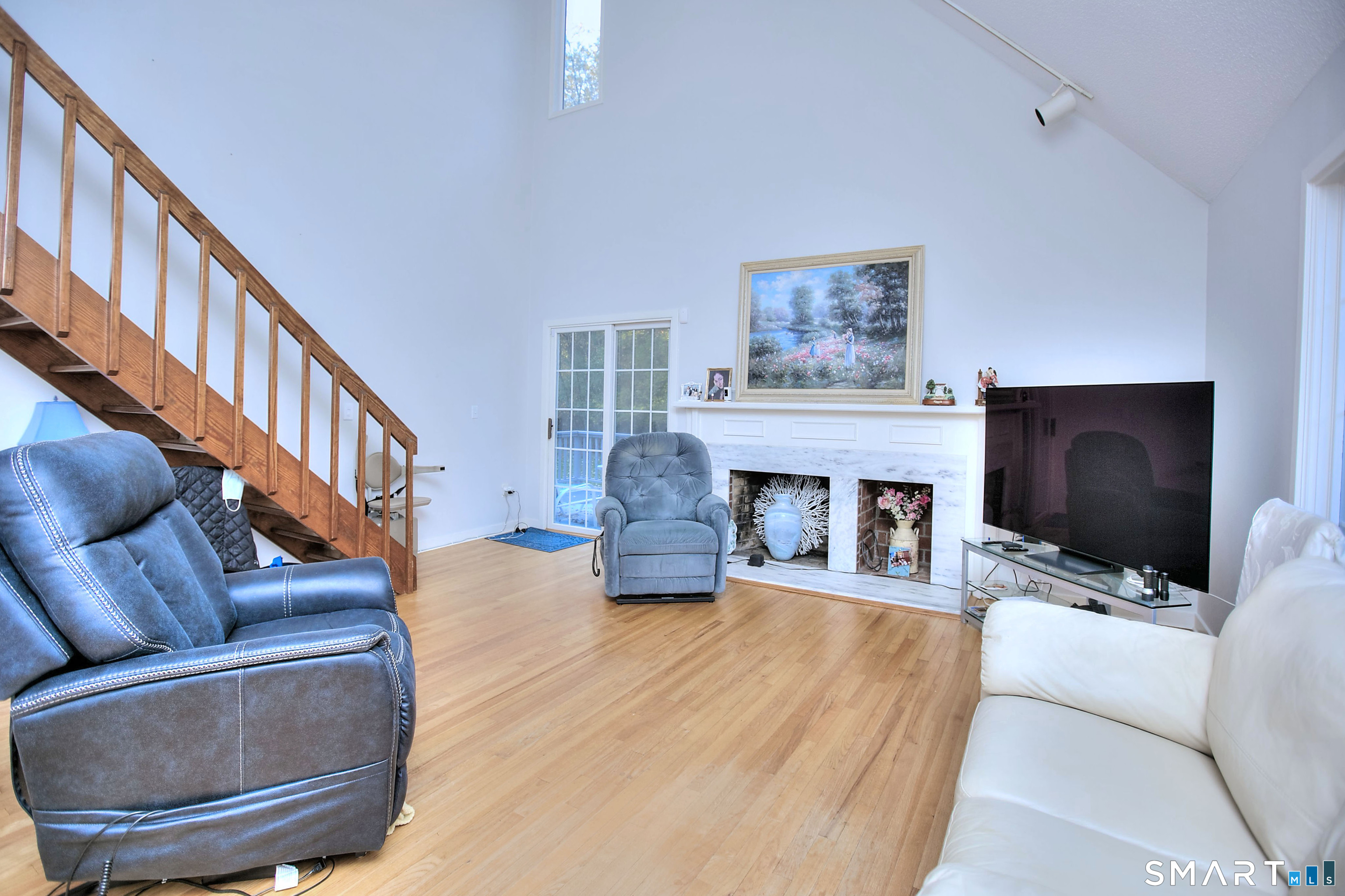 160 Glengarry Road, Unit 160 Fairfield, CT 06825 - Photo 15 of 31 a living room with furniture a fireplace and a flat screen tv