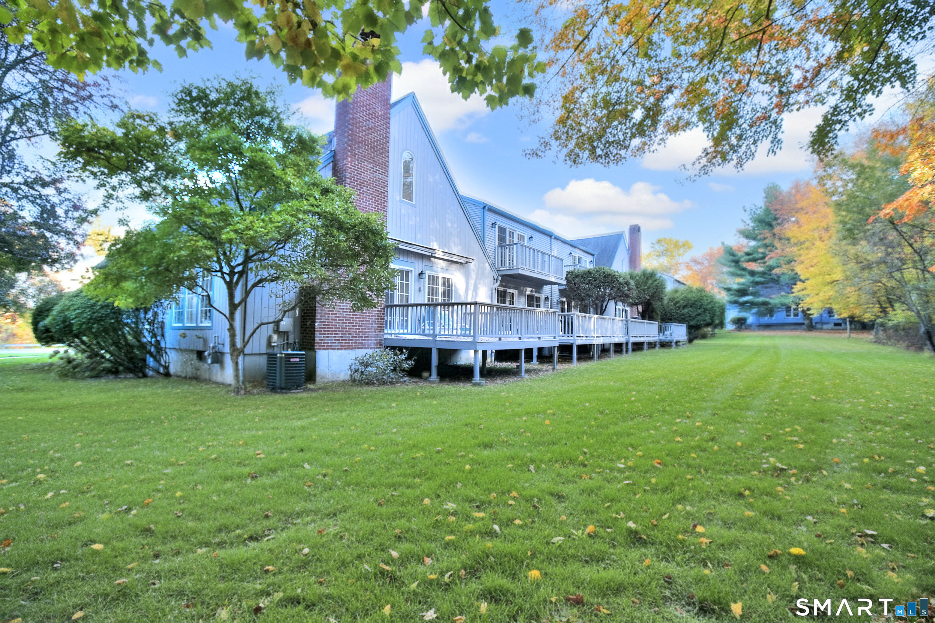 160 Glengarry Road, Unit 160 Fairfield, CT 06825 - Photo 3 of 31 a view of a house next to a big yard and large trees