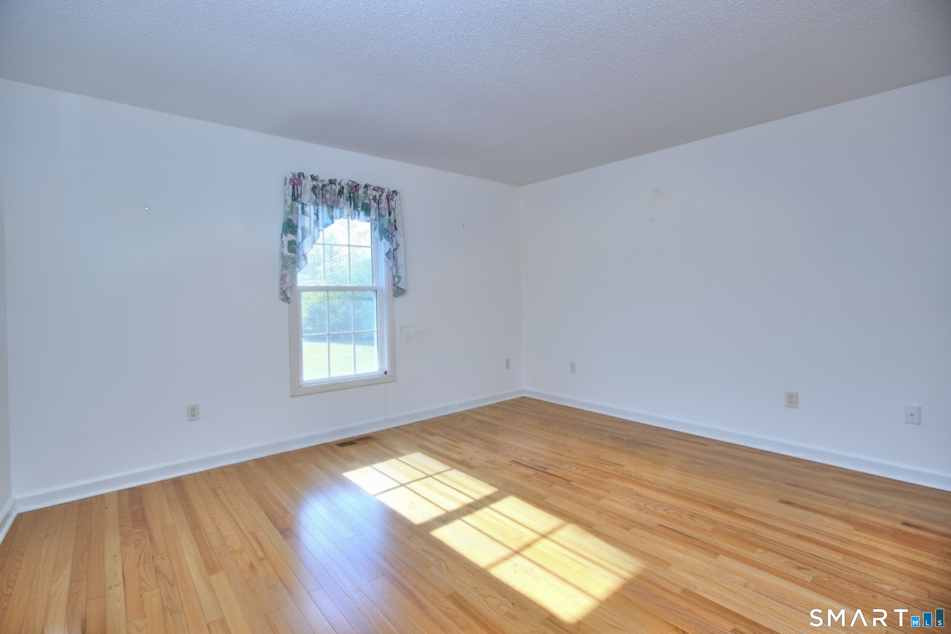 160 Glengarry Road, Unit 160 Fairfield, CT 06825 - Photo 9 of 31 a view of empty room with wooden floor and fan
