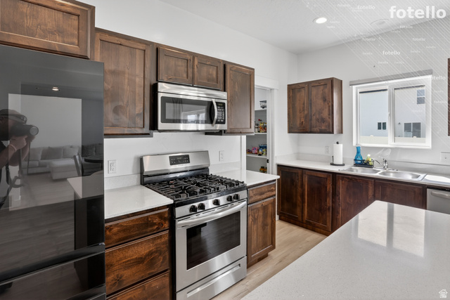 815 West Powderwood Lane Mapleton, UT 84664 - Photo 13 of 39 Kitchen featuring stainless steel appliances, dark wood finish cabinetry, light wood-style flooring, light stone counters, and recessed lighting