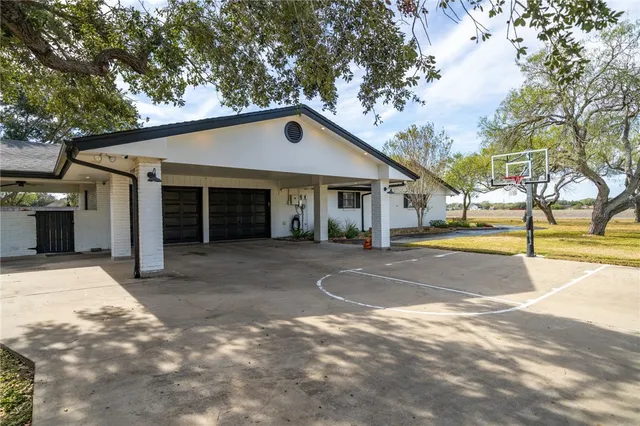 a view of a house with a yard and large tree