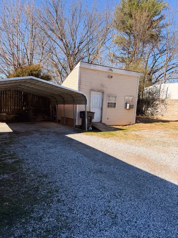 a view of a house with backyard and tree