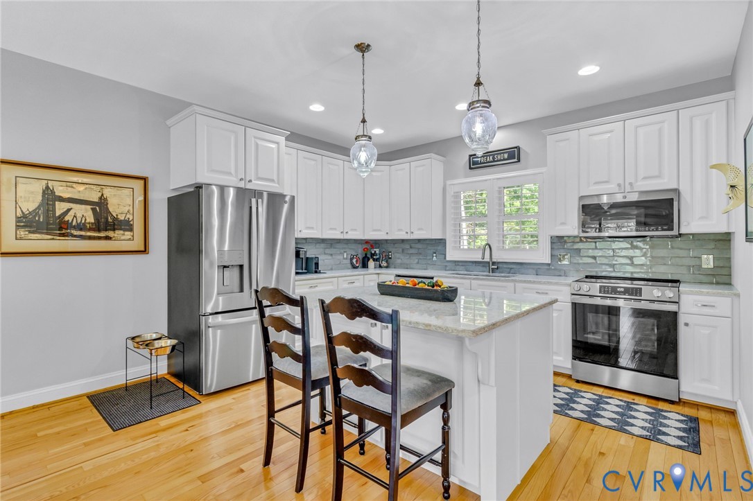 578 High Point Trail Heathsville, VA 22473 - Photo 13 of 50 a kitchen with stainless steel appliances granite countertop a refrigerator a stove top oven a sink dishwasher and a dining table with wooden floor