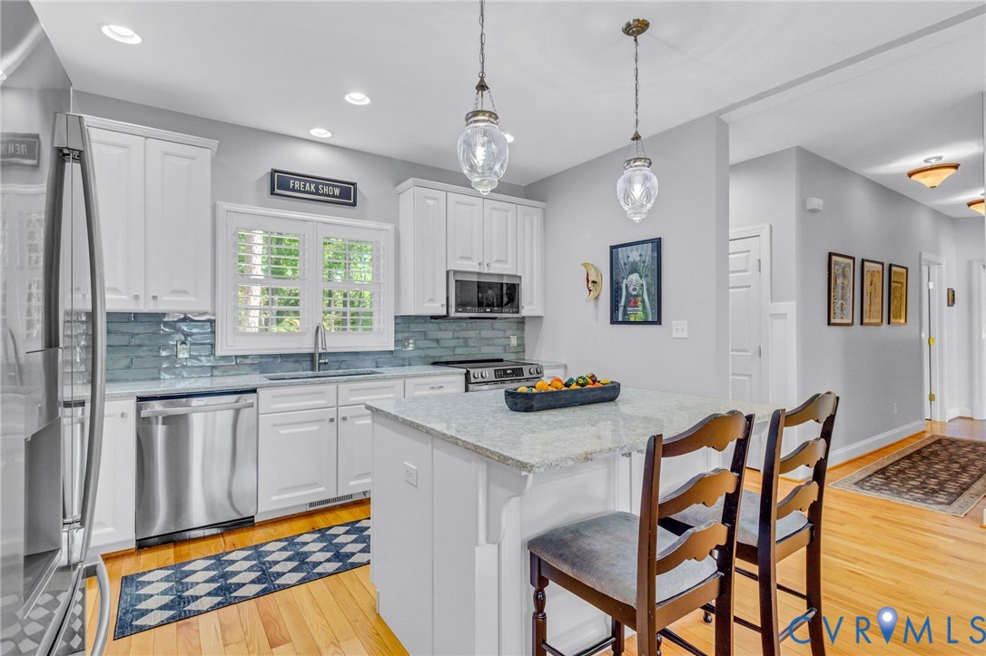 578 High Point Trail Heathsville, VA 22473 - Photo 14 of 50 a kitchen with stainless steel appliances granite countertop a stove a sink dishwasher a dining table and chairs with wooden floor