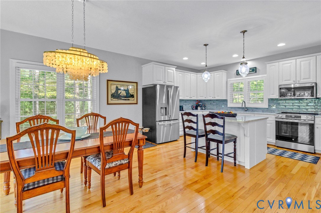 578 High Point Trail Heathsville, VA 22473 - Photo 19 of 50 a kitchen with stainless steel appliances granite countertop a dining table chairs refrigerator and sink