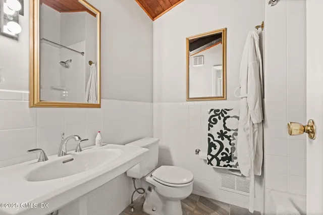 a bathroom with a toilet sink and mirror
