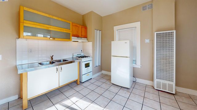 a kitchen with a sink a refrigerator and cabinets