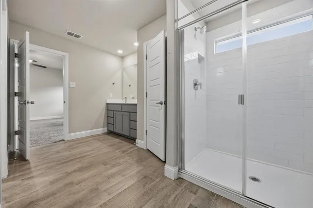 a bathroom with a shower and a glass door
