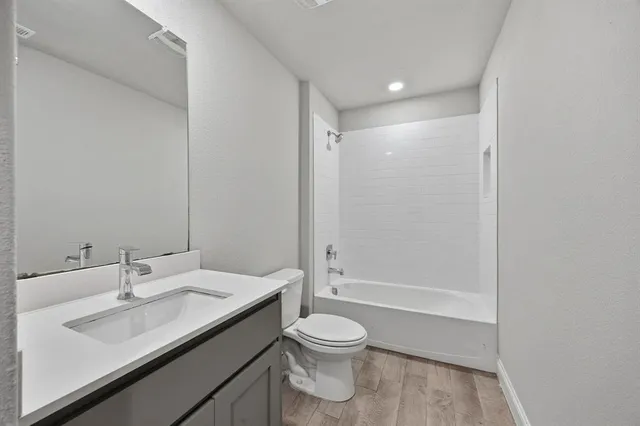 a bathroom with a granite countertop sink toilet a shower and a mirror