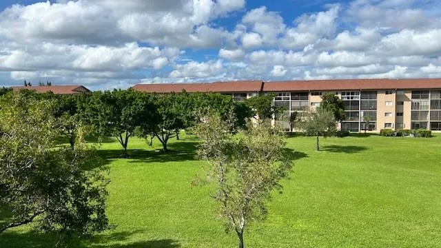 a view of a house with a big yard and a large tree