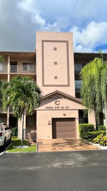 12551 Southwest 16th Court, Unit 306C Pembroke Pines, FL 33027 - Photo 2 of 16 a view of a house with a yard and street