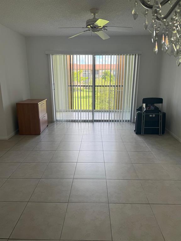 12551 Southwest 16th Court, Unit 306C Pembroke Pines, FL 33027 - Photo 6 of 16 a living room with a large window and chandelier