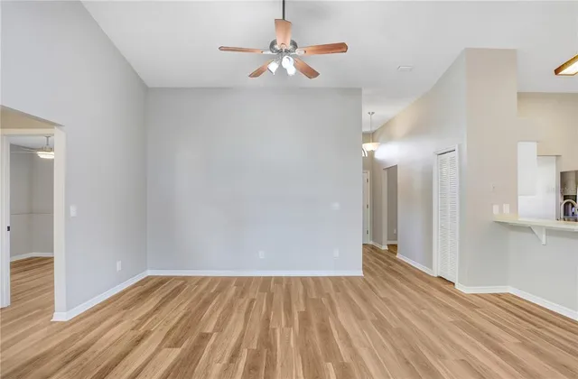 a view of a room with wooden floor and a ceiling fan