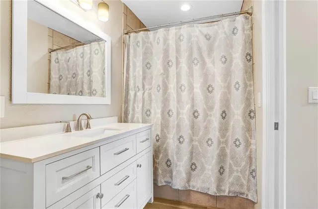a bathroom with a granite countertop sink and a mirror