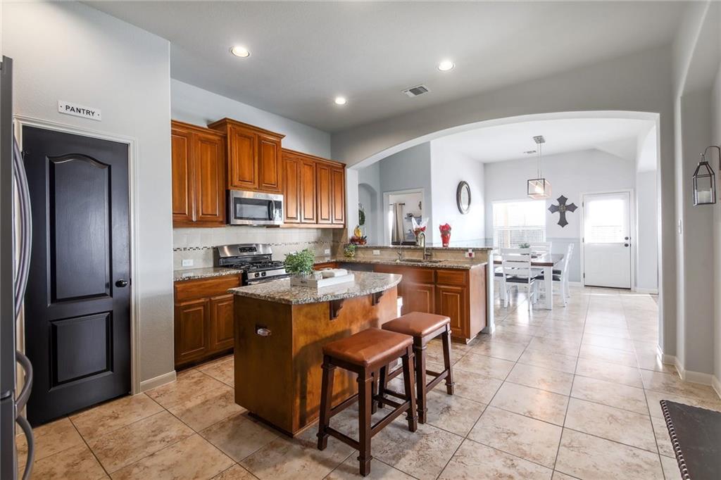 4640 Tiddle Lane Pflugerville, TX 78660 - Photo 12 of 21 a kitchen with stainless steel appliances granite countertop a refrigerator and a sink