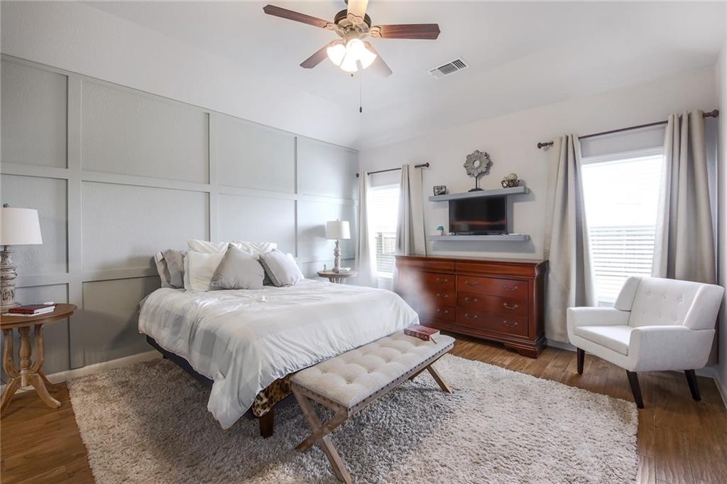 4640 Tiddle Lane Pflugerville, TX 78660 - Photo 7 of 21 a spacious bedroom with a bed a couch and a chandelier