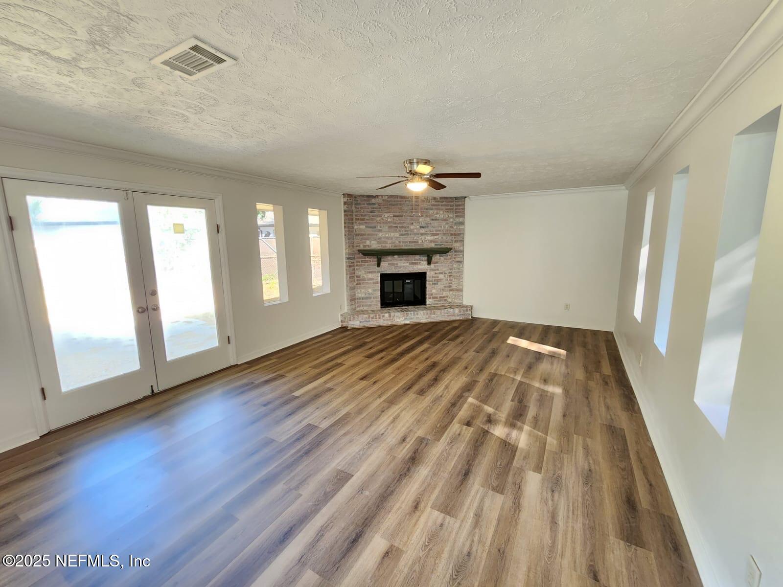 11547 Emuness Road Jacksonville, FL 32218 - Photo 12 of 16 a view of a livingroom with wooden floor and a fireplace