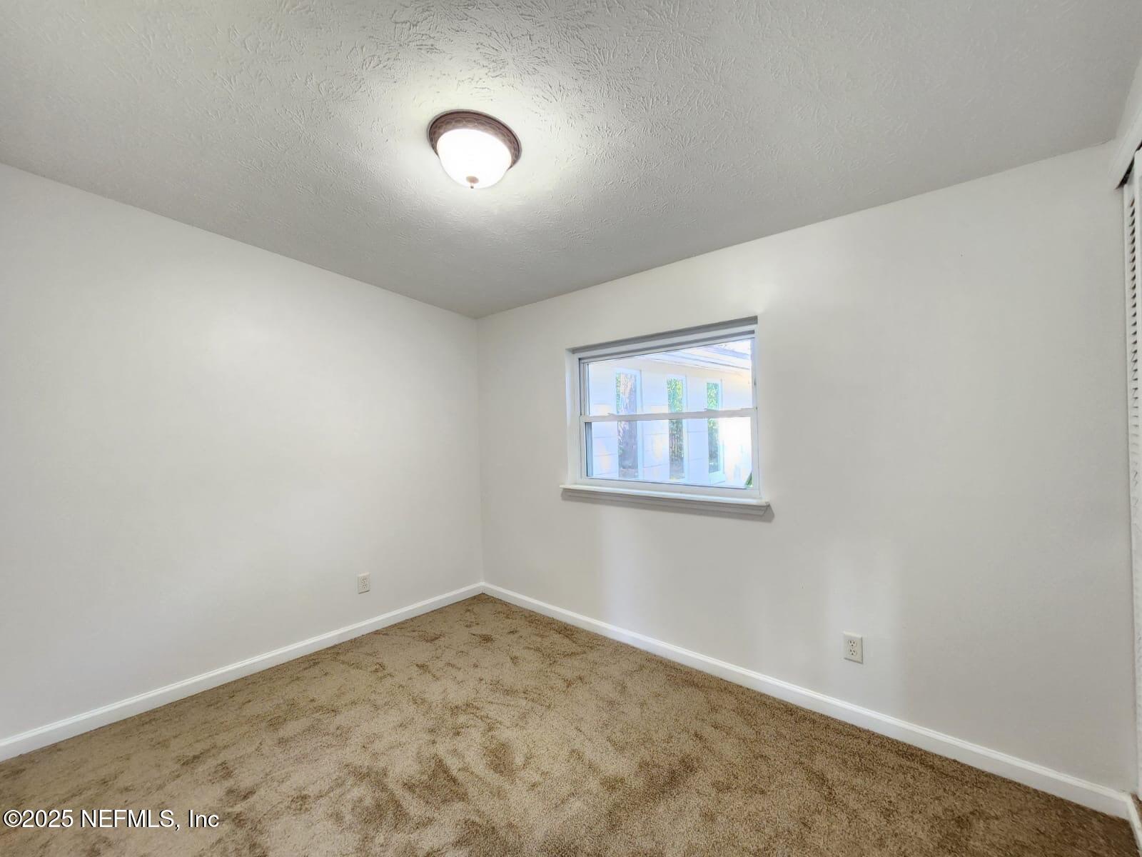 11547 Emuness Road Jacksonville, FL 32218 - Photo 14 of 16 an empty room with a workbench