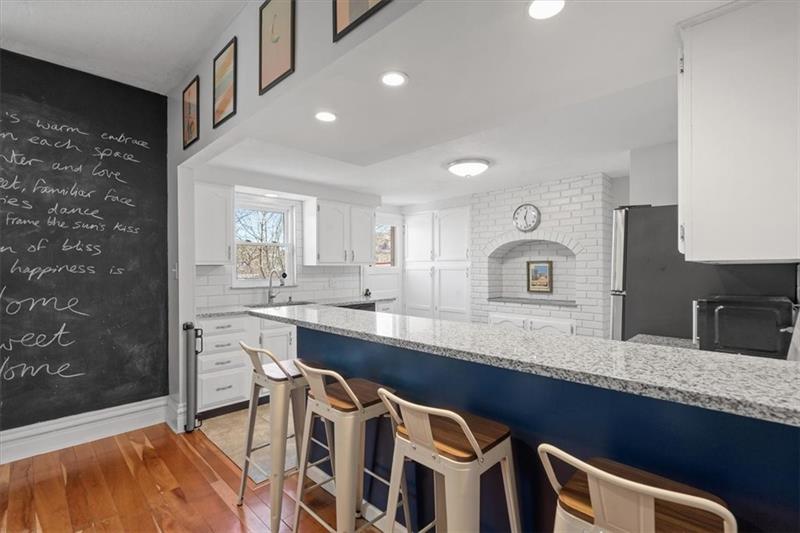 89 Craighead Street Pittsburgh, PA 15211 - Photo 13 of 29 a large kitchen with granite countertop a sink a stove a dining table and chairs
