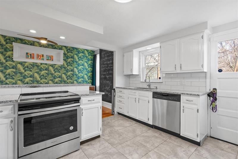 89 Craighead Street Pittsburgh, PA 15211 - Photo 16 of 29 a kitchen with stainless steel appliances wooden floor sink and wooden cabinets