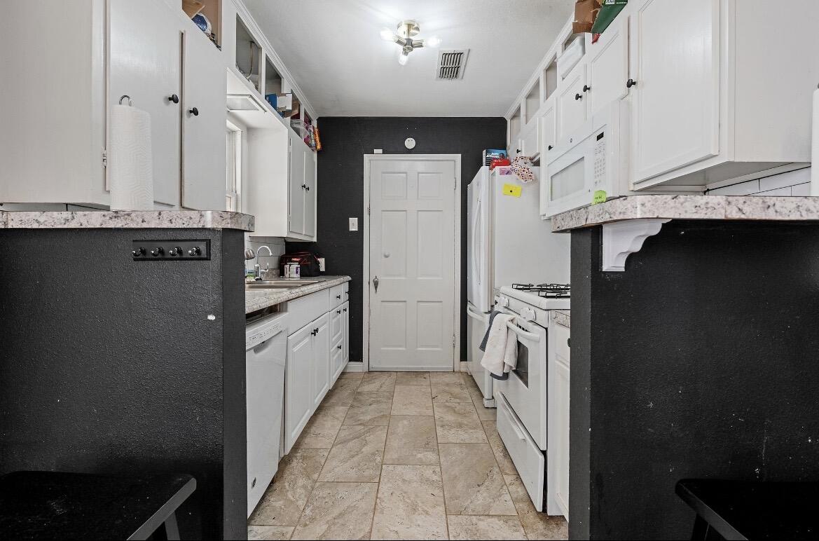 2511 28th Street Lubbock, TX 79410 - Photo 3 of 15 a kitchen with granite countertop a refrigerator and a sink