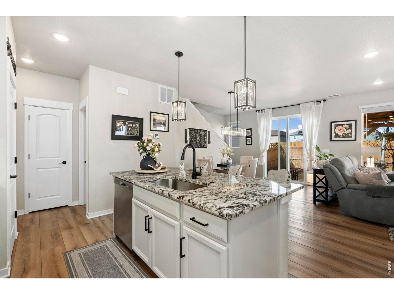 4433 Haymill Court Timnath, CO 80547 - Photo 14 of 39 a kitchen with stainless steel appliances granite countertop a stove a sink dishwasher and white cabinets with wooden floor