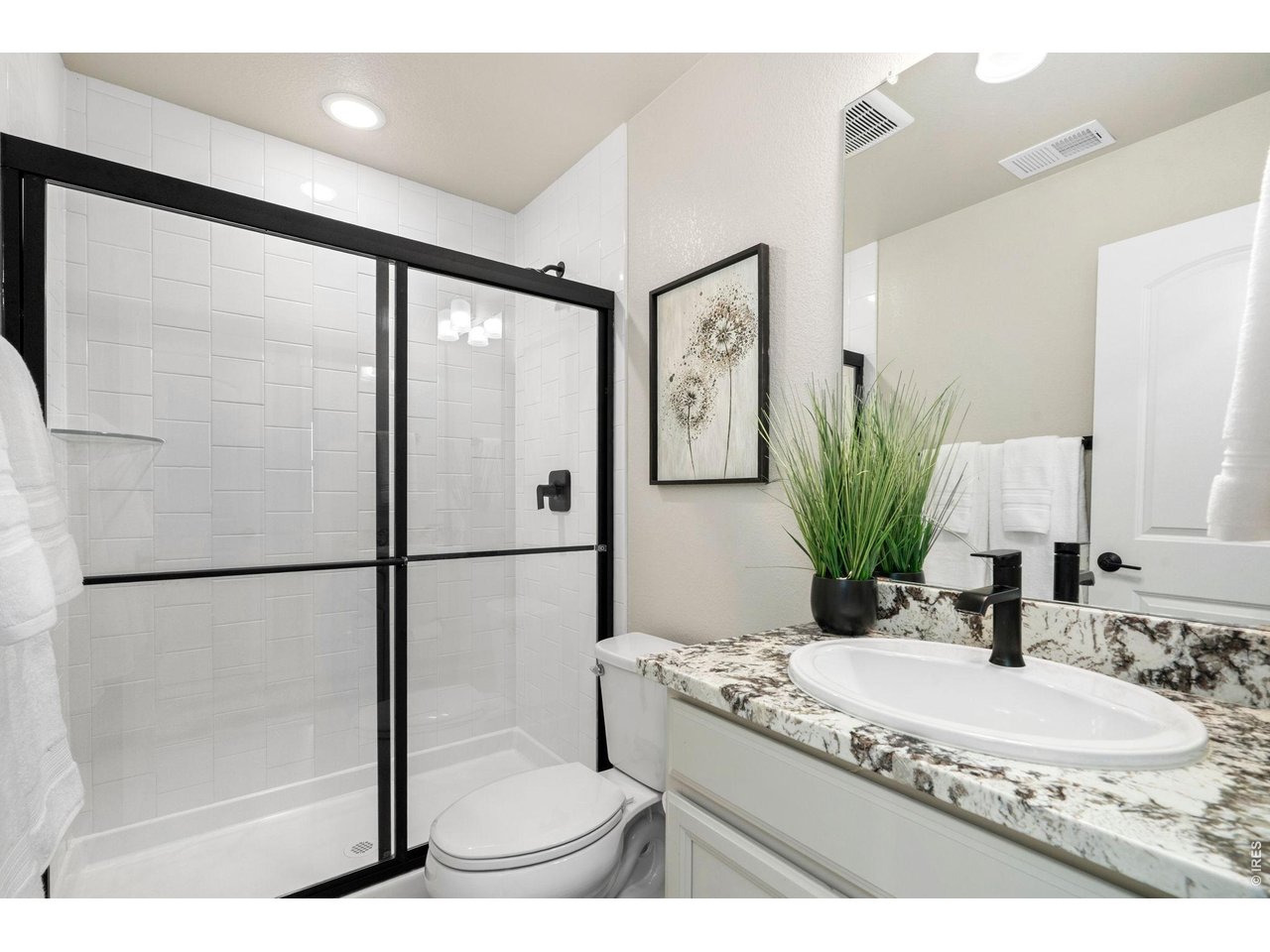 4433 Haymill Court Timnath, CO 80547 - Photo 34 of 39 a bathroom with a granite countertop sink a mirror and shower