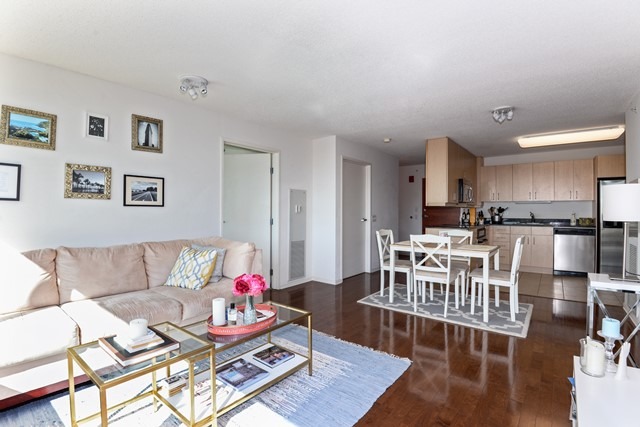 800 Elgin Road, Unit 1210 Evanston, IL 60201 - Photo 4 of 15 a living room with furniture and a dining table with wooden floor