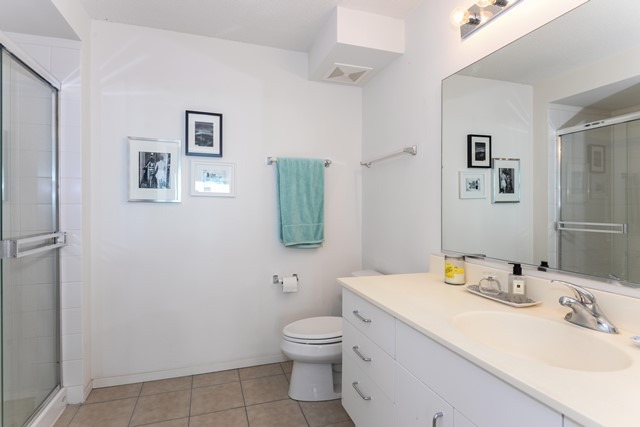800 Elgin Road, Unit 1210 Evanston, IL 60201 - Photo 8 of 15 a bathroom with a granite countertop sink toilet and mirror