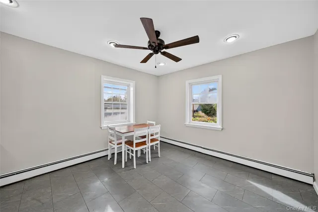 a dining room with a window and a ceiling fan