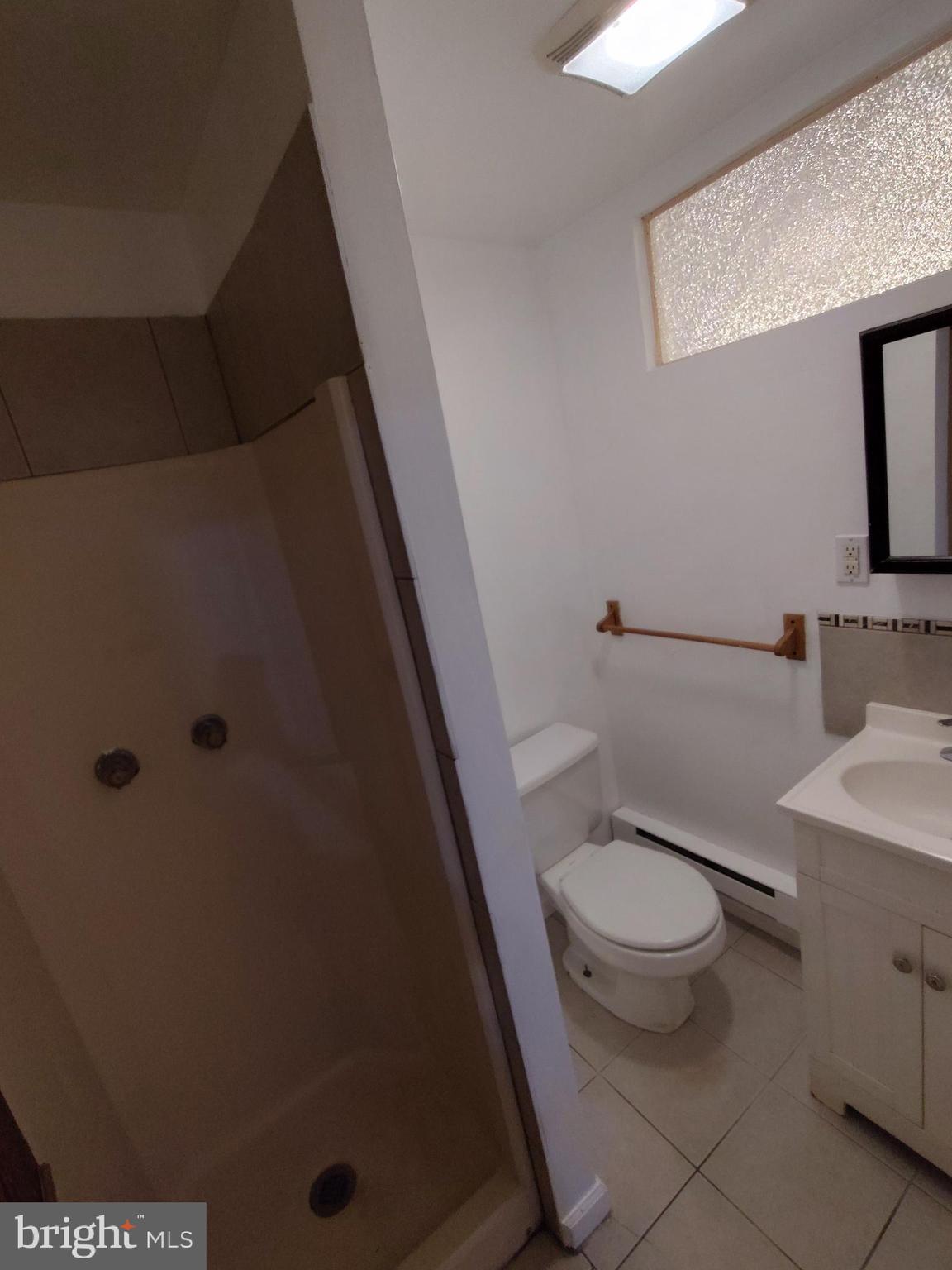 1607 Page Street Philadelphia, PA 19121 - Photo 8 of 14 a white toilet sitting next to a bathroom sink and a mirror
