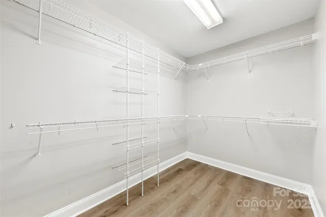 an empty room with windows and chandelier fan