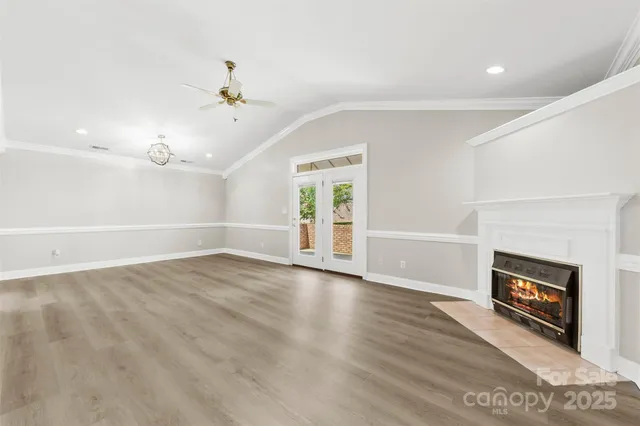 an empty room with windows and fireplace