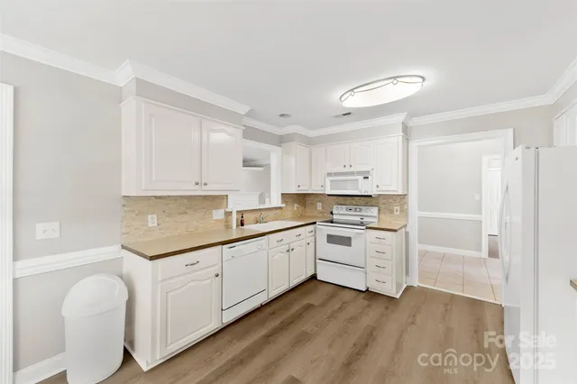 a kitchen with white cabinets appliances and a sink