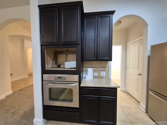 a view of kitchen with granite countertop cabinets and sink