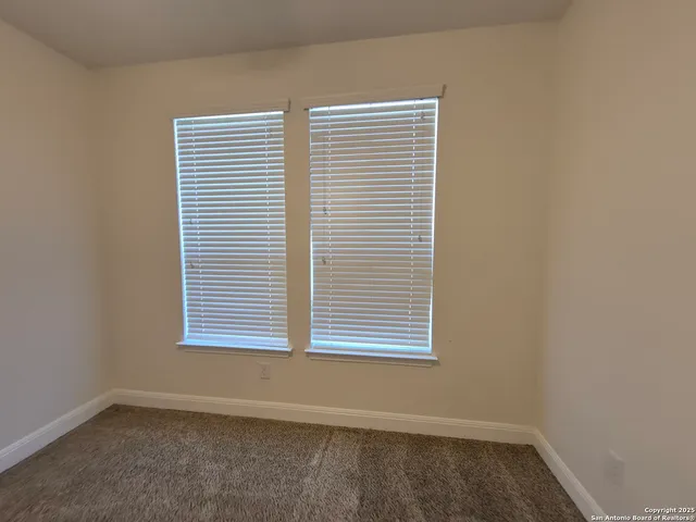 an empty room with a fan and a ceiling fan