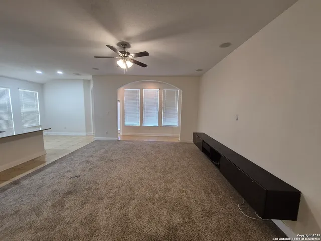 a view of a livingroom with a ceiling fan and window
