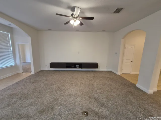 a view of a livingroom with a ceiling fan window and a ceiling fan