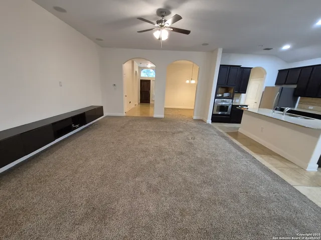 a large kitchen with stainless steel appliances a large counter top a stove and cabinets