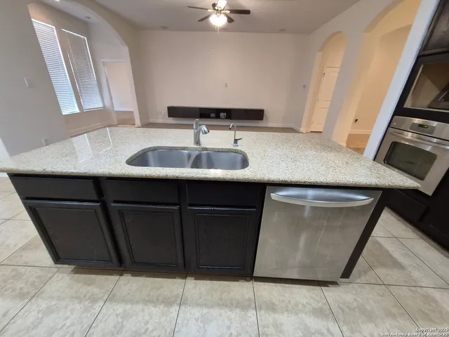 a kitchen with granite countertop wooden cabinets and stainless steel appliances