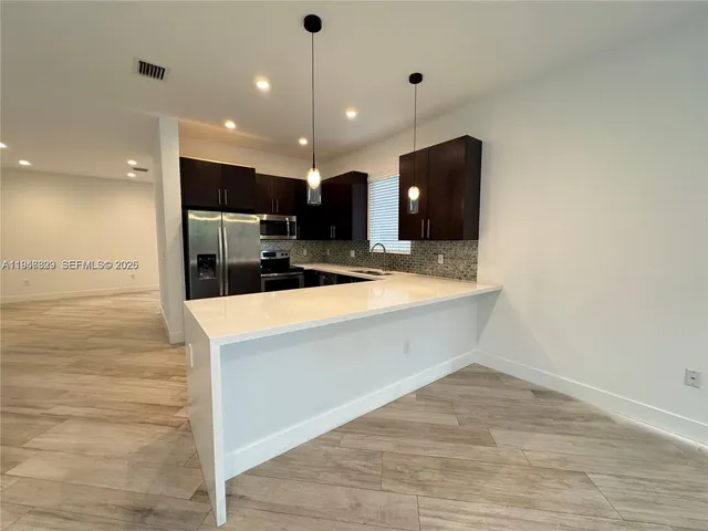 a view of a kitchen with a sink and a large mirror