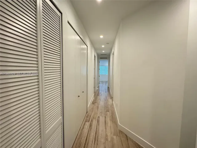 a view of a hallway with wooden floor