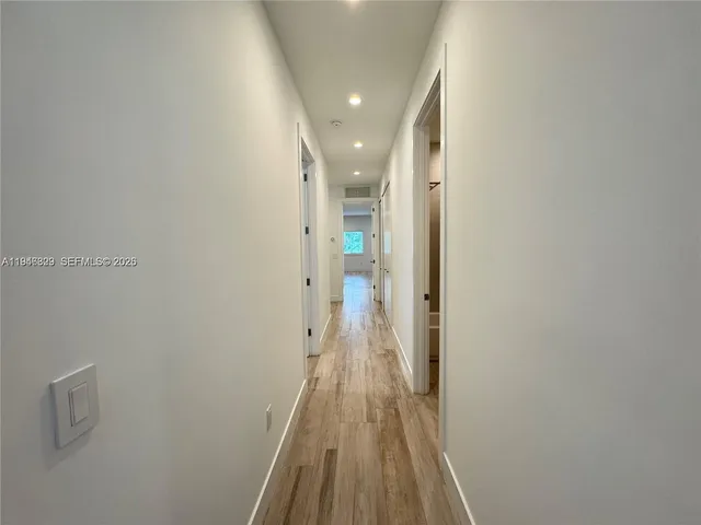 a view of a hallway with wooden floor